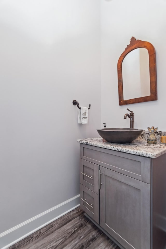 bathroom with vanity, wood finished floors, and baseboards
