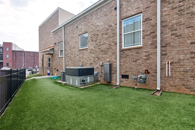 back of property with central AC unit and brick siding