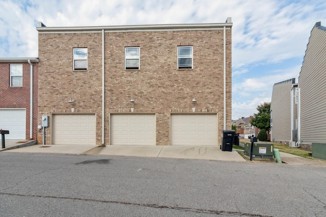 back of house featuring brick siding and an attached garage