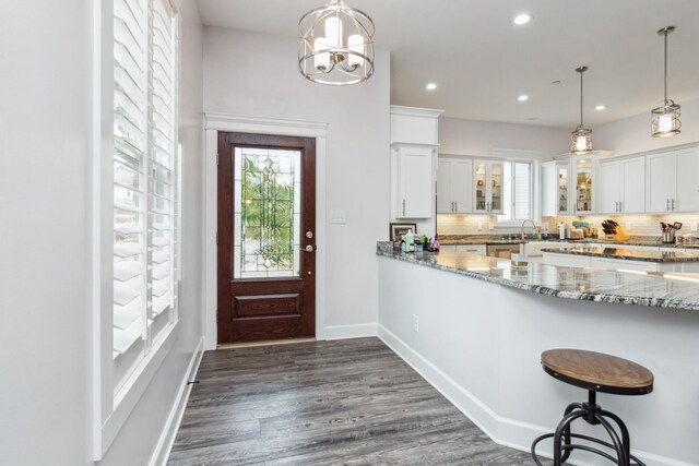 entrance foyer with plenty of natural light, dark wood-style floors, recessed lighting, baseboards, and a chandelier