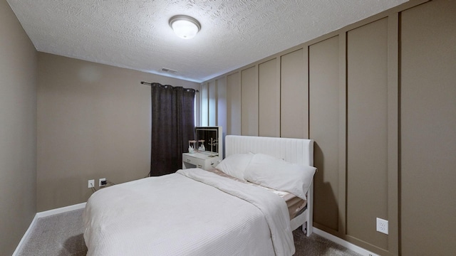 carpeted bedroom with baseboards and a textured ceiling