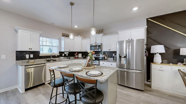 kitchen featuring stainless steel appliances, light wood-style flooring, backsplash, white cabinets, and recessed lighting