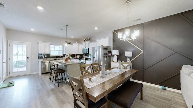 dining area featuring light wood-style flooring, a chandelier, recessed lighting, and baseboards