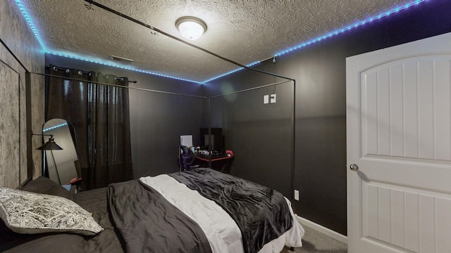 carpeted bedroom with a textured ceiling and baseboards