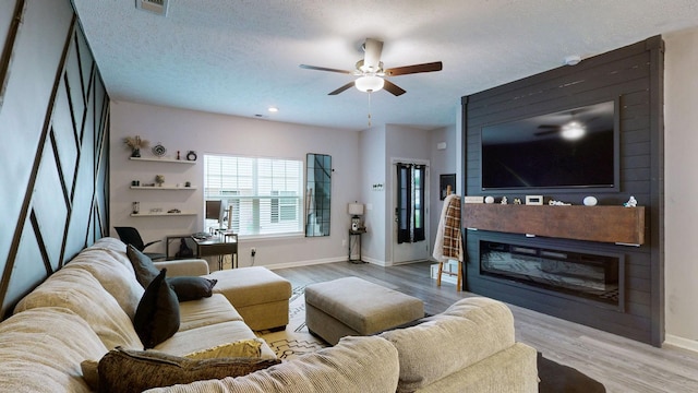living area featuring baseboards, ceiling fan, and wood finished floors