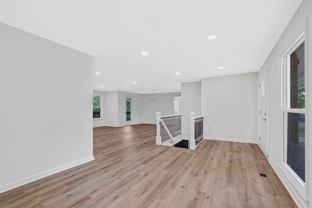 empty room featuring wood finished floors, ornamental molding, recessed lighting, and baseboards
