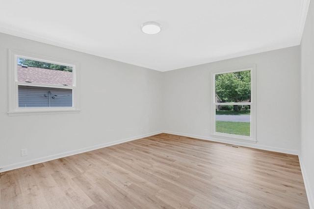 empty room featuring light wood finished floors and baseboards