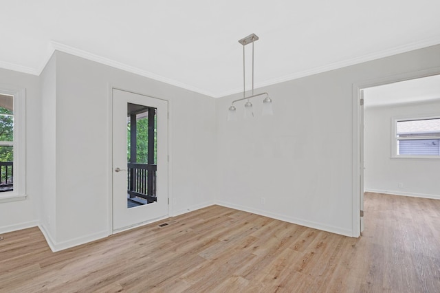 unfurnished dining area with light wood finished floors, ornamental molding, and plenty of natural light
