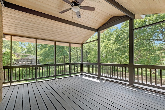 wooden terrace with ceiling fan and view of wooded area