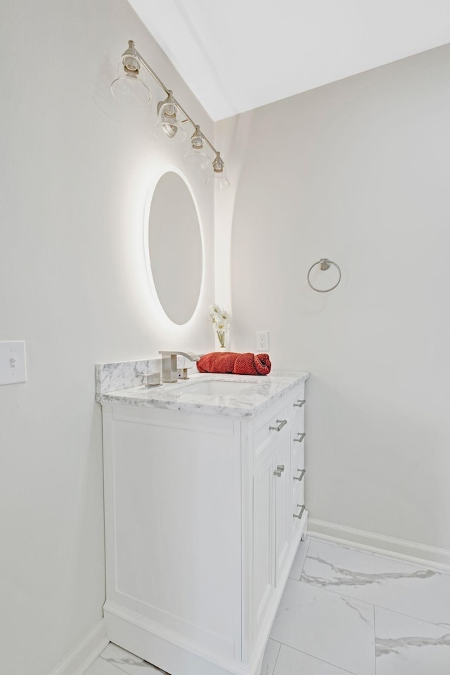 bathroom with marble look tile flooring, baseboards, and vanity