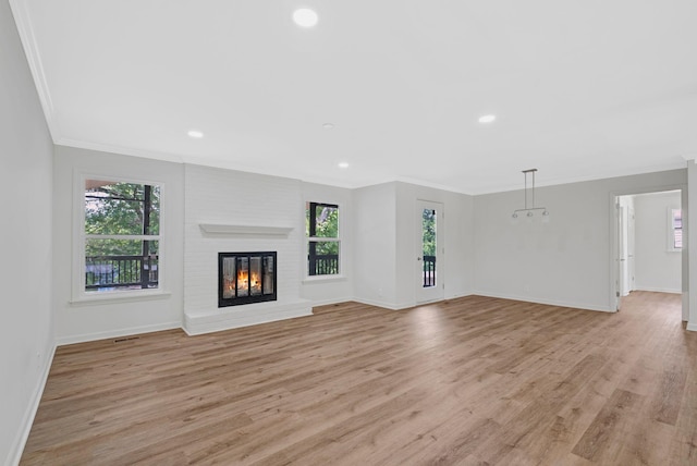 unfurnished living room with plenty of natural light, baseboards, ornamental molding, light wood-style flooring, and recessed lighting