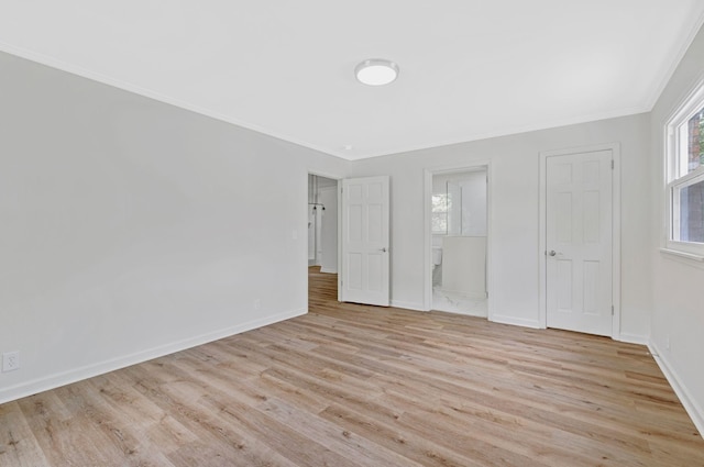 unfurnished bedroom featuring light wood finished floors, crown molding, and baseboards