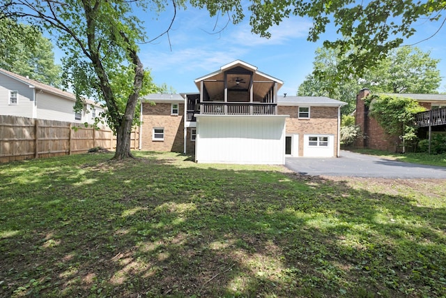 rear view of house with brick siding, asphalt driveway, and a balcony