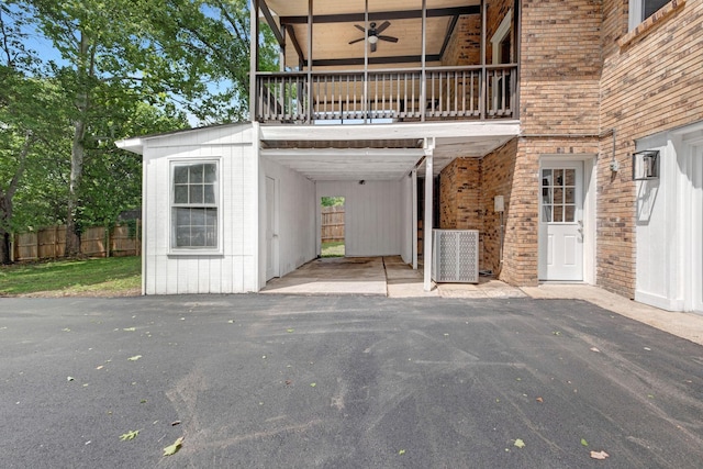 exterior space featuring a ceiling fan, brick siding, and fence