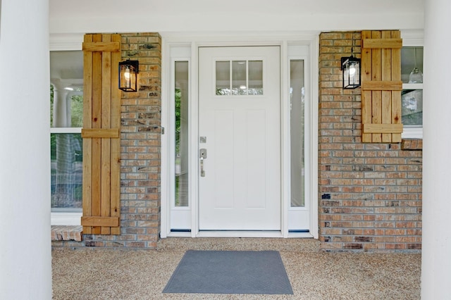 property entrance featuring brick siding and a porch