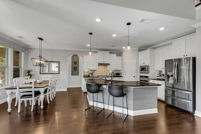 1030 Brixworth Dr, Thompsons Station, TN 37179 - kitchen with appliances with stainless steel finishes, dark countertops, crown molding, decorative backsplash, and white cabinetry