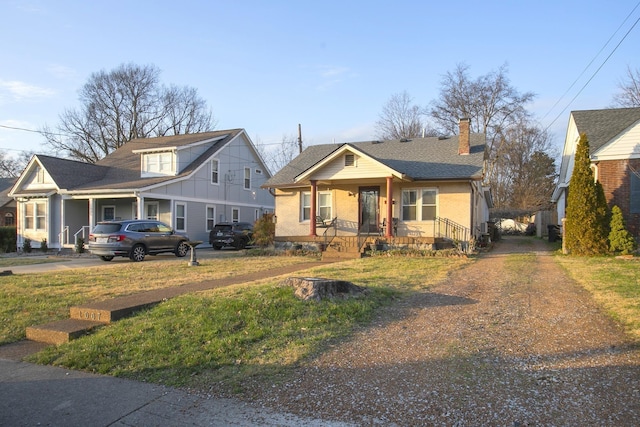 bungalow-style house with a porch, a chimney, driveway, and board and batten siding