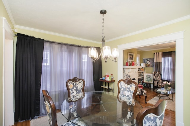 dining room with a chandelier, wood finished floors, and ornamental molding