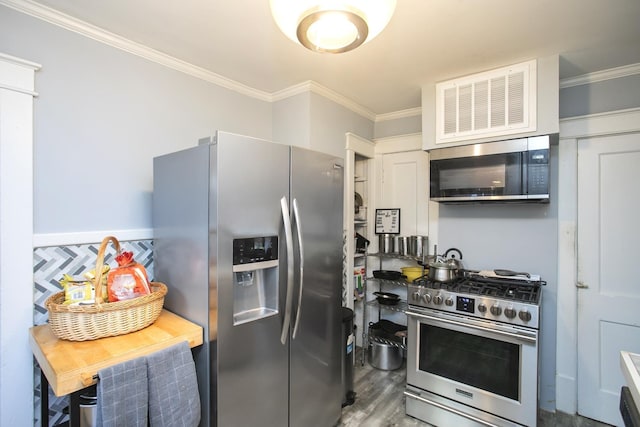 kitchen with appliances with stainless steel finishes, crown molding, and wood finished floors