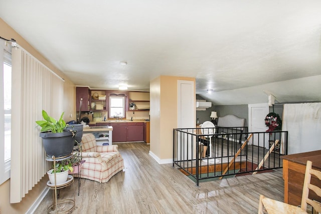 sitting room with an upstairs landing, light wood finished floors, and baseboards