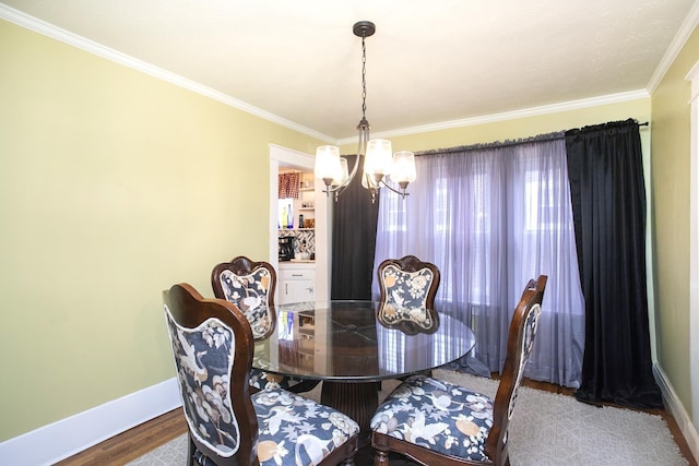 dining room with a chandelier, baseboards, wood finished floors, and crown molding