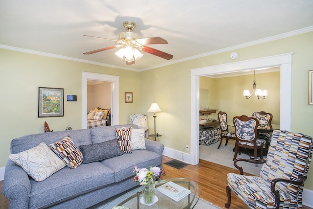 living room featuring wood finished floors, crown molding, a chandelier, a ceiling fan, and baseboards