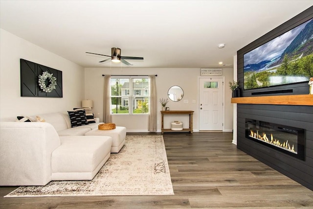 living area featuring wood finished floors, a large fireplace, a ceiling fan, and recessed lighting