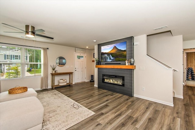 living room with wood finished floors, a ceiling fan, a fireplace, baseboards, and recessed lighting