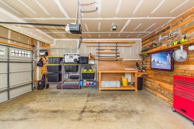 garage with a garage door opener and wooden walls