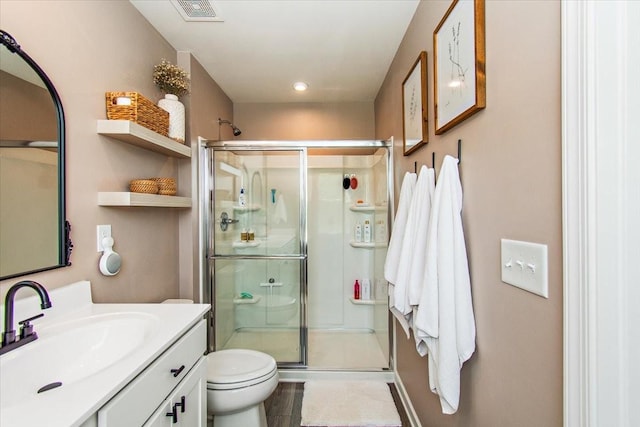 bathroom with a stall shower, vanity, toilet, tile patterned floors, and recessed lighting