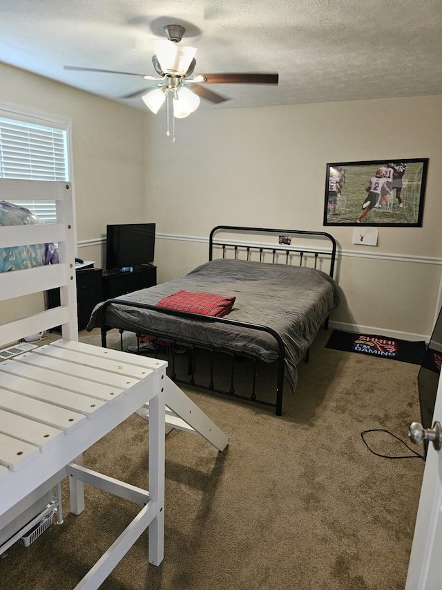 bedroom featuring carpet flooring, ceiling fan, and a textured ceiling