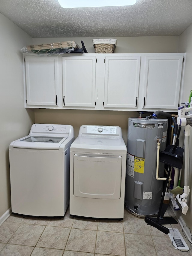 laundry room featuring electric water heater, cabinet space, independent washer and dryer, a textured ceiling, and light tile patterned floors