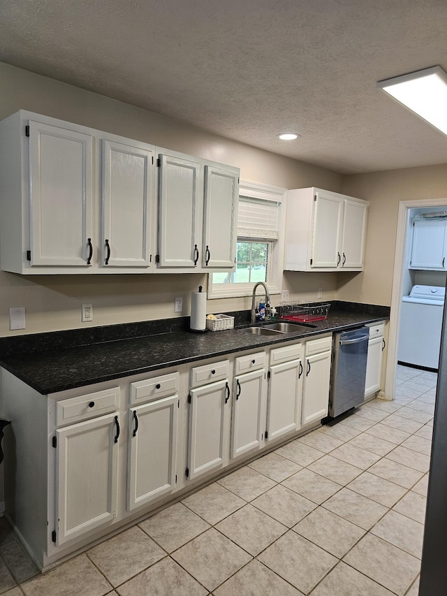 kitchen with dishwasher, washer / dryer, a sink, white cabinets, and a textured ceiling
