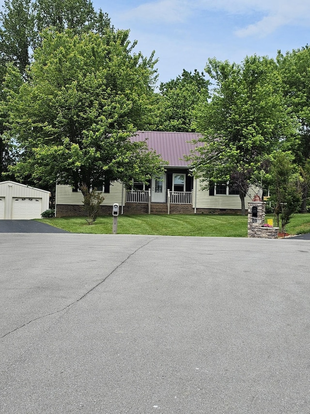 obstructed view of property with an outdoor structure, a front lawn, metal roof, and a detached garage