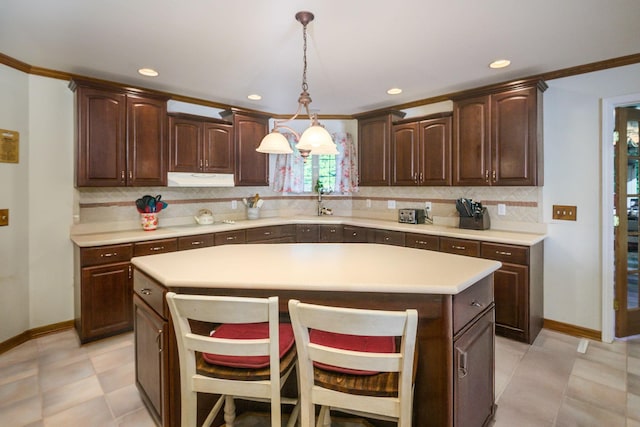 168 Maple Valley Ln, Cookeville, TN 38506 - kitchen with tasteful backsplash, light countertops, dark brown cabinets, decorative light fixtures, and a kitchen bar