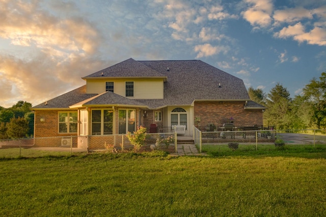 168 Maple Valley Ln, Cookeville, TN 38506 - back of house at dusk featuring brick siding, a sunroom, and a shingled roof