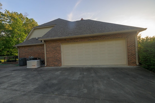 168 Maple Valley Ln, Cookeville, TN 38506 - view of side of home featuring brick siding, central air condition unit, roof with shingles, and an attached garage