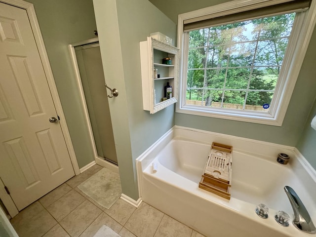 full bath featuring tile patterned flooring, a stall shower, and a garden tub