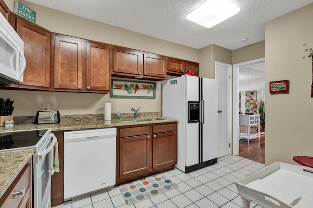 536 River St Unit 536, Chattanooga, TN 37405 - kitchen featuring white appliances, a sink, brown cabinetry, a textured ceiling, and light tile patterned flooring