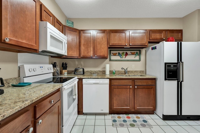 536 River St Unit 536, Chattanooga, TN 37405 - kitchen with white appliances, a sink, brown cabinetry, light tile patterned floors, and light stone counters