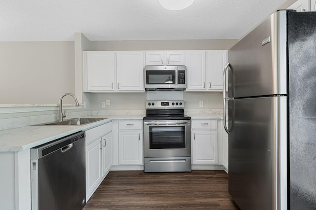 608 Flintlock Ct, Nashville, TN 37217 - kitchen with stainless steel appliances, a sink, light countertops, white cabinets, and a textured ceiling