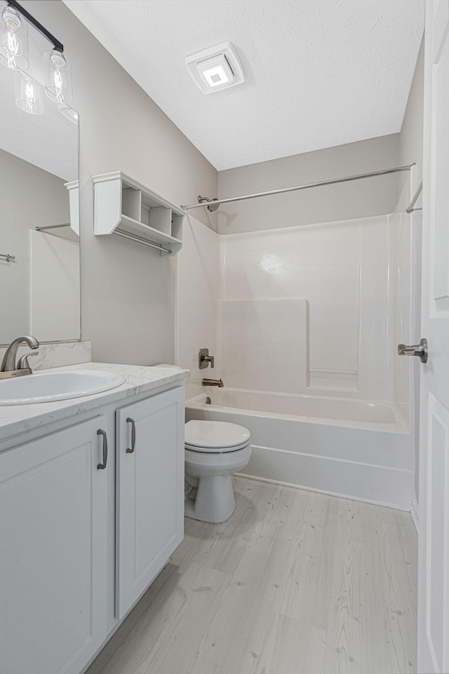 608 Flintlock Ct, Nashville, TN 37217 - bathroom featuring toilet, wood finished floors, tub / shower combination, vanity, and a textured ceiling