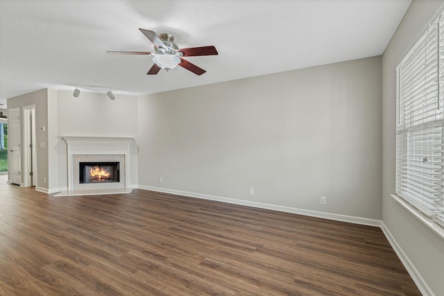 608 Flintlock Ct, Nashville, TN 37217 - unfurnished living room featuring healthy amount of natural light, a ceiling fan, dark wood-type flooring, a warm lit fireplace, and a textured ceiling
