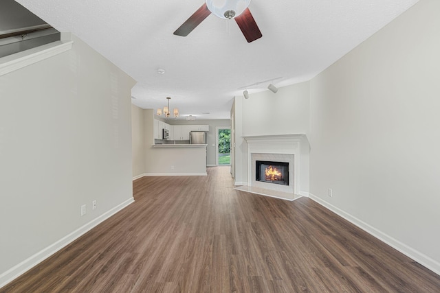 608 Flintlock Ct, Nashville, TN 37217 - unfurnished living room featuring a chandelier, dark wood finished floors, ceiling fan, a lit fireplace, and baseboards