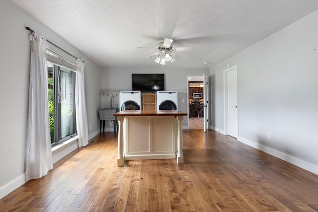 office with a ceiling fan, washer / dryer, light wood finished floors, and baseboards