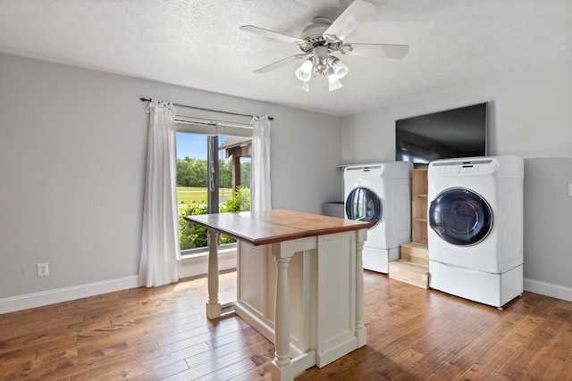 laundry room featuring washing machine and dryer, wood finished floors, baseboards, and a ceiling fan