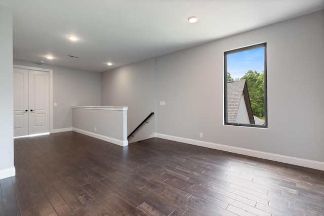 unfurnished room with dark wood finished floors, baseboards, and recessed lighting