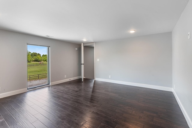 spare room featuring baseboards, dark wood finished floors, and recessed lighting