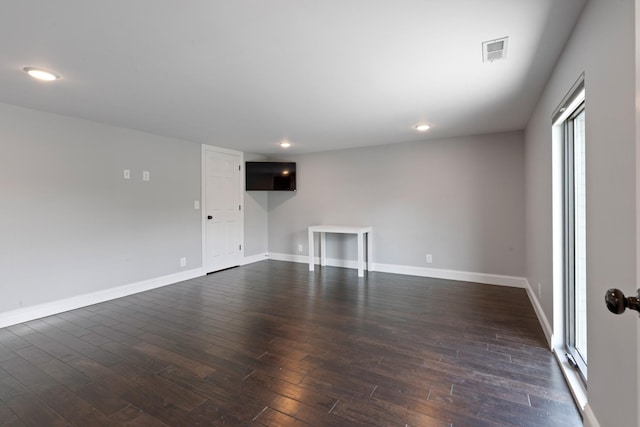 empty room featuring dark wood finished floors, baseboards, and recessed lighting