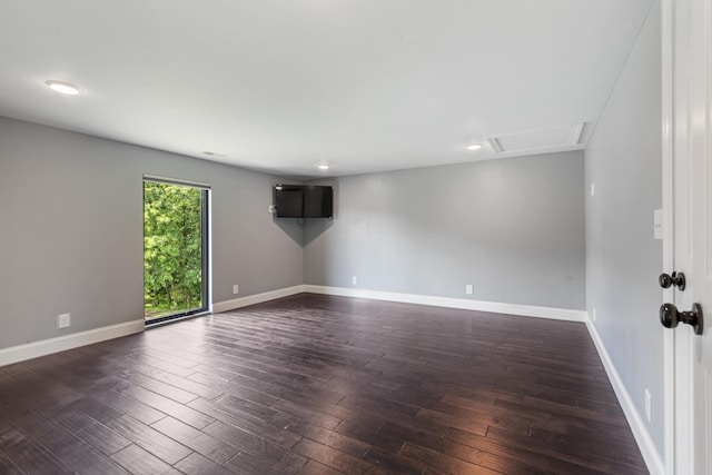 spare room with dark wood-style floors, baseboards, attic access, and recessed lighting
